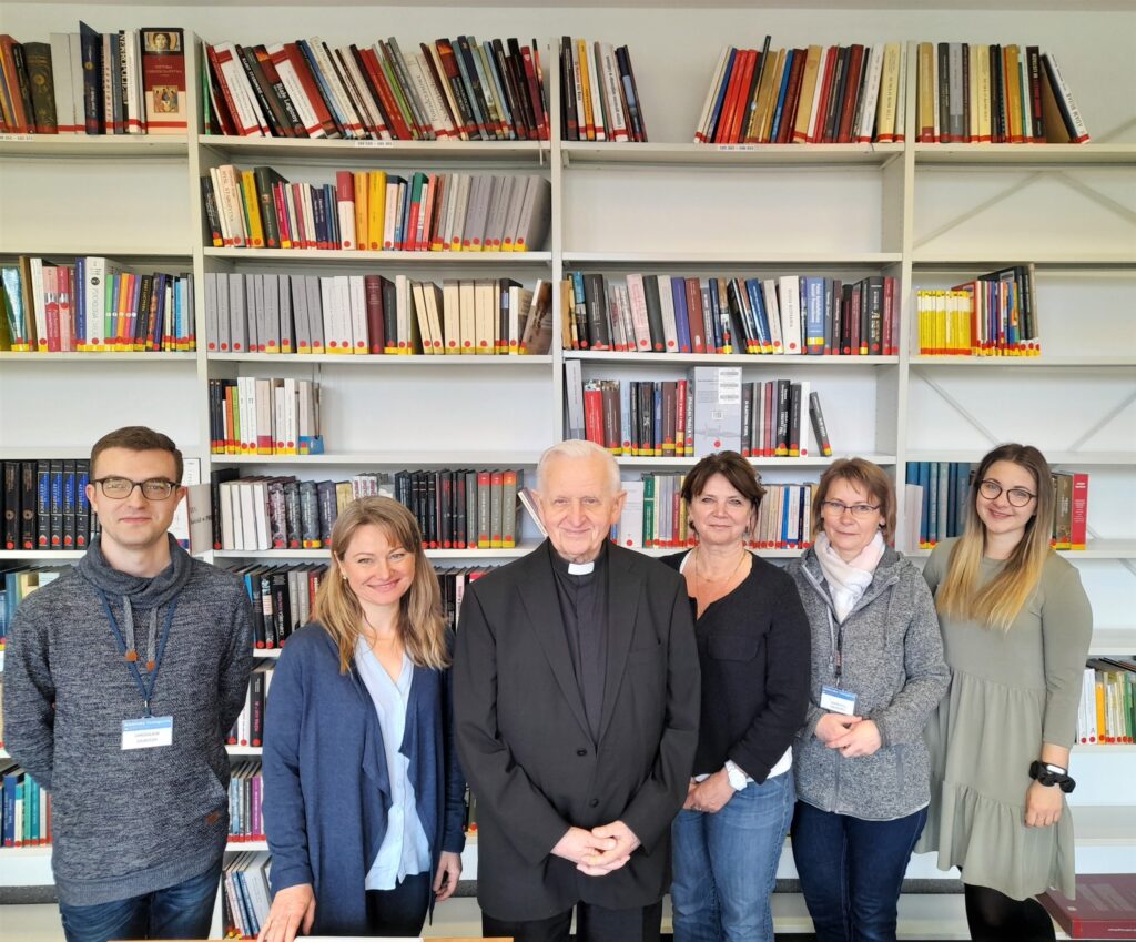 Fotografia arcybiskupa Damiana Zimonia z pracownikami biblioteki.